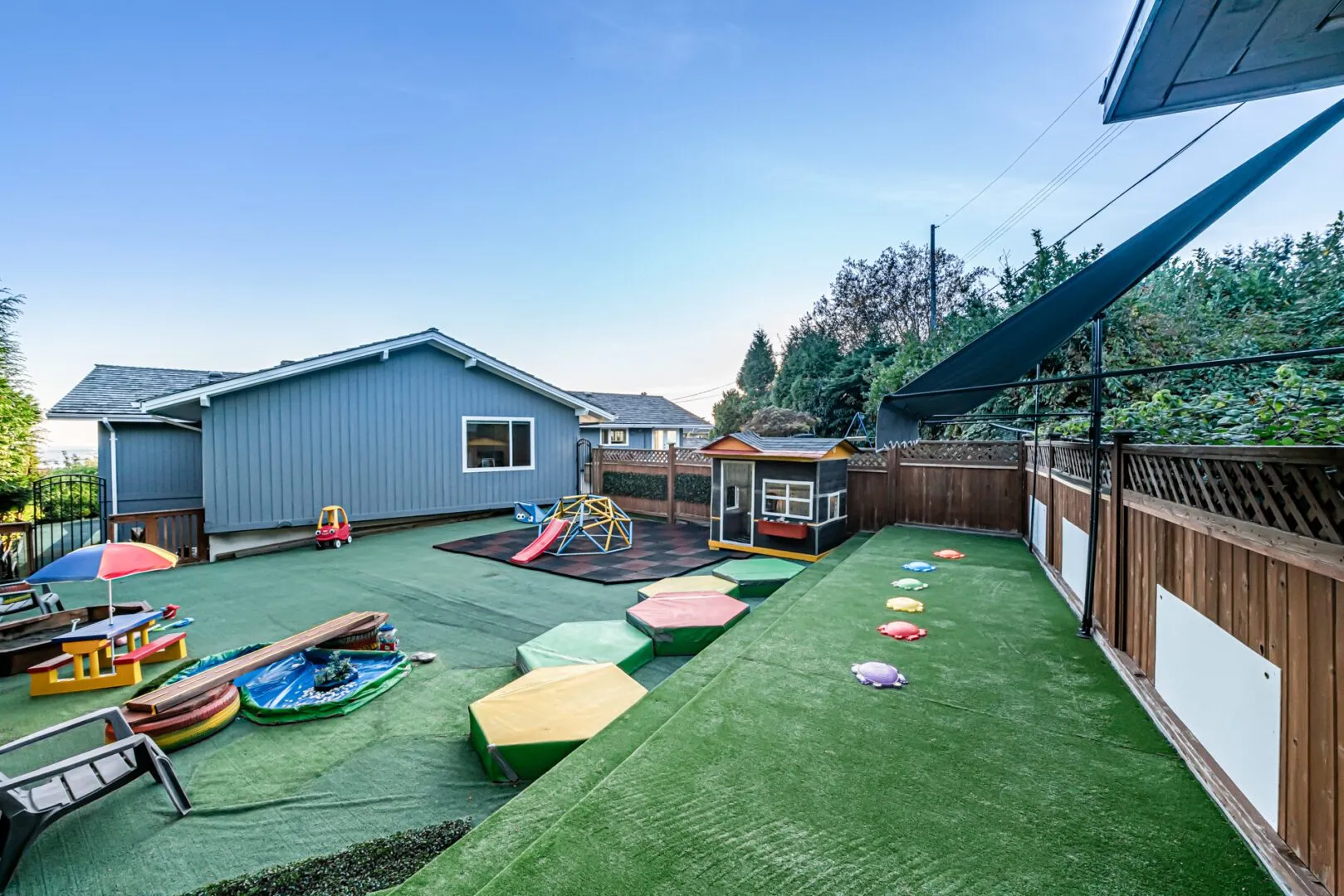 Backyard play area with colourful stepping stones, playhouse and garden views